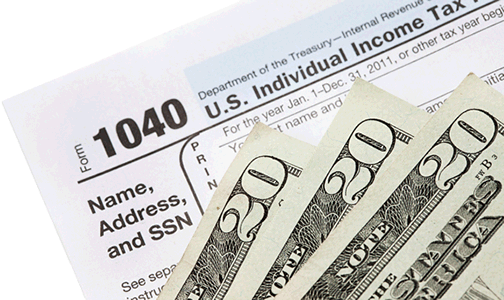 IRS form 1040 with 3, $20 bills